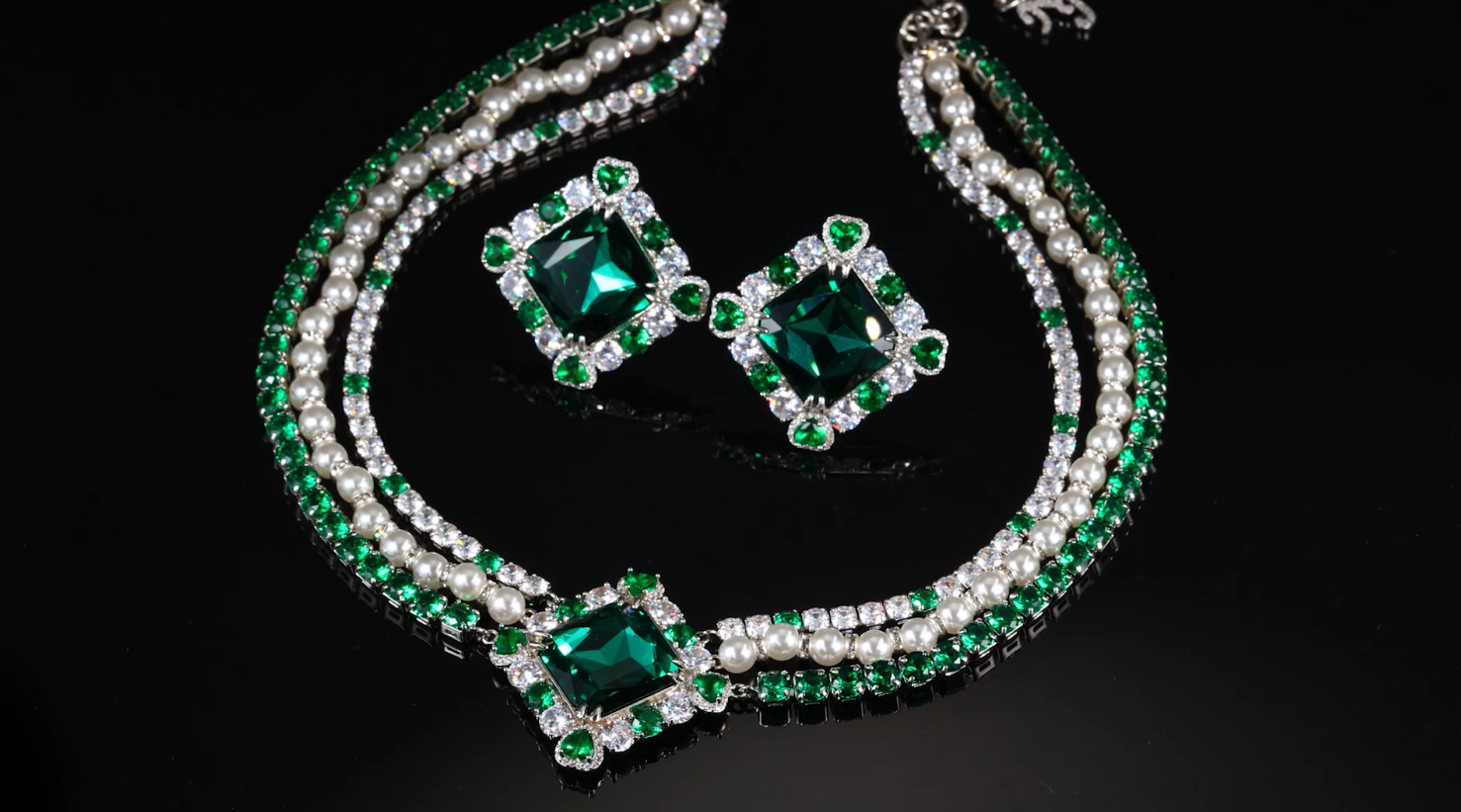 Crystal-embellished diamond shape necklace with green emerald accents.