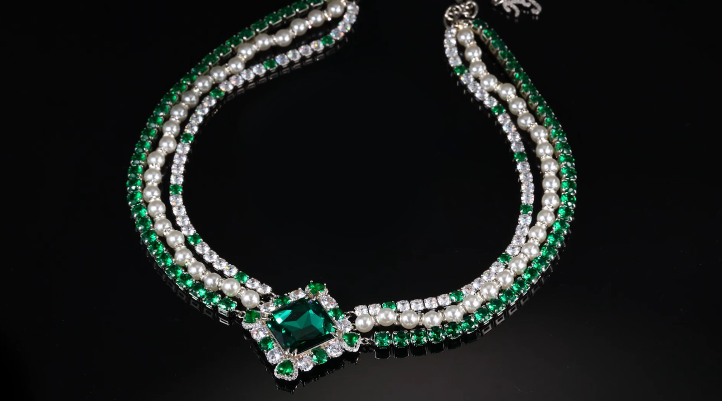 Crystal-embellished diamond shape necklace with green emerald accents.